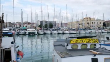 Catania Sicilya limanına yanaşmış tekne ve yatların huzurlu manzarası berrak mavi su günışığıyla ve rahat Akdeniz havasıyla.