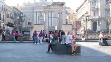 Turistler Catania Sicilya 'nın ana meydanında yürürken San Placido Kilisesi sakinleri de dahil olmak üzere tarihi yerleri çevrelediler. Şehir yaşamının hareketli sokaklarının tadını çıkarıyorlar. İtalyan atmosferi Catania Sicania İtalya 10.05.2025