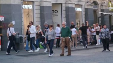 Turistler Catania Sicilya 'nın ana meydanında yürürken San Placido Kilisesi sakinleri de dahil olmak üzere tarihi yerleri çevrelediler. Şehir yaşamının hareketli sokaklarının tadını çıkarıyorlar. İtalyan atmosferi Catania Sicania İtalya 10.05.2025