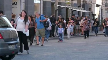 Turistler Catania Sicilya 'nın ana meydanında yürürken San Placido Kilisesi sakinleri de dahil olmak üzere tarihi yerleri çevrelediler. Şehir yaşamının hareketli sokaklarının tadını çıkarıyorlar. İtalyan atmosferi Catania Sicania İtalya 10.05.2025