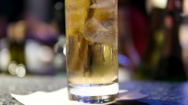 Hızlı çekimle cin tonik hazırlama işlemi çok yavaş ilerliyor. Yüksek hızlı sinema kamerası, 1000 fps, yüksek hızlı sinüs robotuna yerleştirilmiş. Arka planda şişe olan bir bar. Hız rampası.