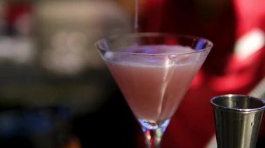 Lokantada yakın plan kokteyl. Tezgahın arkasındaki barmen buzlu kokteyl yapar. Margarita bardağında buz küpleri. Barmen Shaker 'ı sallıyor. Özel alkollü kokteyl servisi. damlalar.