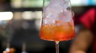 Parlak bir yaz kokteyli hazırlama süreci. İçinde portakal kabuğu özü de var. Barmen içkiye narenciye tazeliği vermek için kabuğu büker. Yüksek kalite 4k görüntü