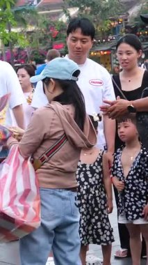 Otantik Hoi Bir Vietnam yaşam tarzı turistlerin canlı kültürel seyahat sahnelerinde yürüdüğü eski şehir caddeleri nehirde yüzen tekneler ve kafede eğlenen insanlar. Hoi Bir Vietnam 10.02.2025