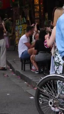 Renkli Hoi Dar sokakları keşfeden insanlarla dolu bir Vietnam nehir kenarındaki kafelerde dinlenen tribünlerde dinlenen ve su üzerinde hareket eden tekneler canlı bir yaşam tarzı kültürel seyahat Vietnam Hoi 10.02.2025