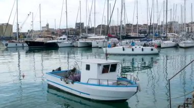 Catania Sicilya limanına yanaşmış tekne ve yatların huzurlu manzarası berrak mavi su günışığıyla ve rahat Akdeniz havasıyla.
