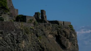 Aci Castello Norman kalesi, Catania Sicilya yakınlarındaki İyon Denizi 'ne bakan siyah lav uçurumunda duruyor. İtalya tarihi ortaçağ kalesi ve manzaralı Akdeniz kıyıları..