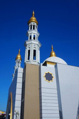 Caminin ihtişamı ve mavi gökyüzünün altında yükselen minaresi çarpıcı bir manzara yaratıyor.