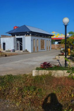 Cami arazisi ve cami imamı, mavi gökyüzüne karşı.