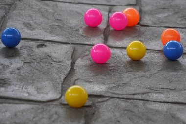 Beton zeminde küçük renkli toplar, genellikle çocuklar tarafından oynamak için kullanılır.