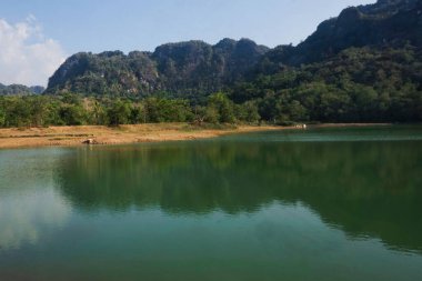 Öğleden sonra berrak su gölleri, dağlar ve ağaçların manzarası