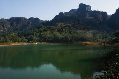 Öğleden sonra berrak su gölleri, dağlar ve ağaçların manzarası