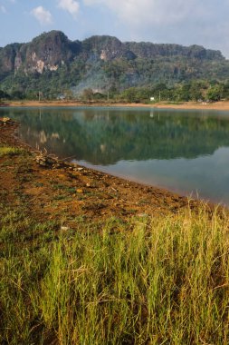 Dağlık zemini olan göl kenarındaki sarı çimlerin görüntüsü