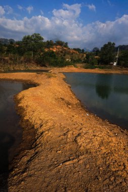 Manzara berrak su, dağlar ve ağaçlarla dolu bir göldür.