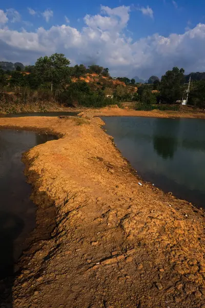 Manzara berrak su, dağlar ve ağaçlarla dolu bir göldür.