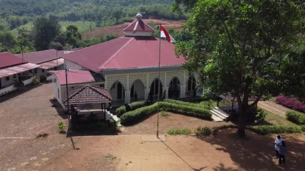 明るい日にモスクの前に飛んでいるインドネシアの赤と白の旗の眺め — ストック動画