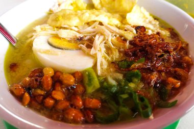 Bubur Ayam, beyaz pirinç lapası, tavuk, kraker, taze soğan ve yumurtadan oluşan geleneksel Endonezya yemeği..