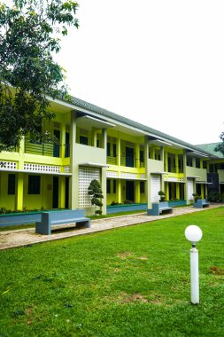 Okul binası yeşil ve arkadaşları yeşil çimenli.