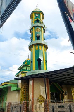 Cami kulesi bulutlu bir günde yeşil, İslam 'ın sembolü.