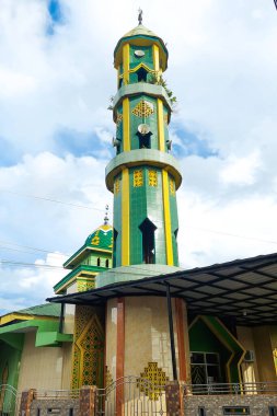 Cami kulesi bulutlu bir günde yeşil, İslam 'ın sembolü.