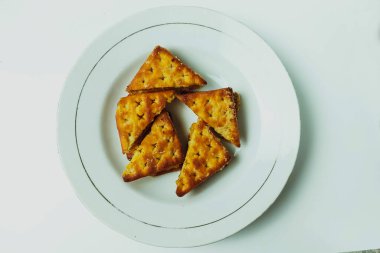 Beyaz bir tabakta beyaz bir masada bisküviler.