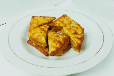 Beyaz bir tabakta beyaz bir masada bisküviler.