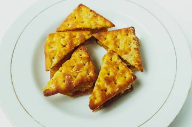 Beyaz bir tabakta beyaz bir masada bisküviler.