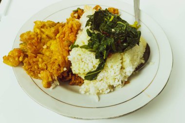 Masadaki beyaz tabakta pilav ve omlet karışımı.