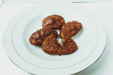 Taripang keki beyaz bir tabakta yemek odasında sade beyaz bir masada.