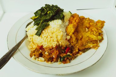 Masadaki beyaz tabakta pilav ve omlet karışımı.