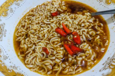 Erişte çorbası ve kırmızı biber, yemek masasında yenmeye hazır.