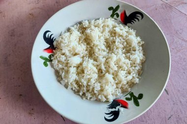 Beyaz pirinç yemek masasındaki beyaz tabakta yenmeye hazır.