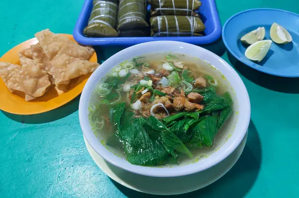 Endonezya yemekleri - Pangsip erişteleri, krakerler, buralar ve portakallar yemek masasında.
