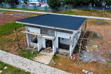 Güneşli bir günde yarısı bitmiş bir evin manzarası