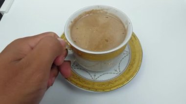 Masada beyaz bardakta kapuçino içilecek.