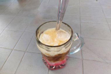 Cam bardaklarda buz ve yemek masasında kaşıklar.