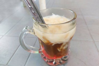 Cam bardaklarda buz ve yemek masasında kaşıklar.