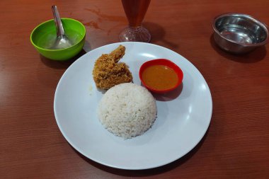 Çıtır tavuk, acılı sos ve beyaz pilav yemek masasında.