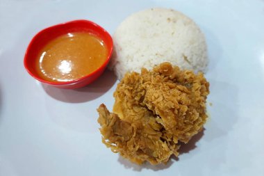 Çıtır tavuk, acılı sos ve beyaz pilav yemek masasında.