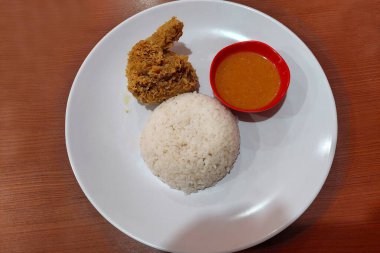 Çıtır tavuk, acılı sos ve beyaz pilav yemek masasında.