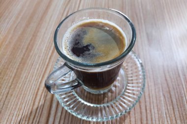 Masadaki bir bardakta kahve ve süt karıştırılmadı.