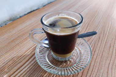 Masadaki bir bardakta kahve ve süt karıştırılmadı.