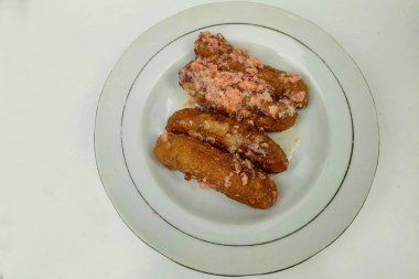 Muzlu kek beyaz bir masada beyaz bir tabakta servis edilir.