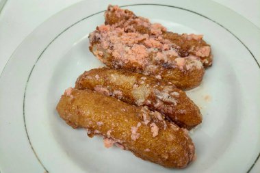 Muzlu kek beyaz bir masada beyaz bir tabakta servis edilir.