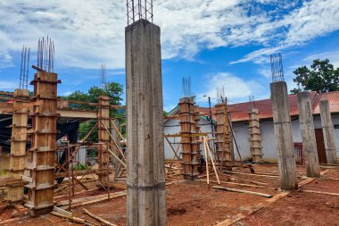 Güneşli bir günde inşaat sırasında beton yapı sütunları