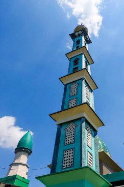 Yüksek caminin kulesi mavi gökyüzü tarafından taşınır.