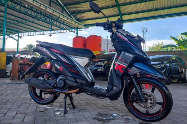 Makassar, Endonezya - 18 Mayıs 2024: Siyah bir X-tride motosikleti park edildi ve yıkandı