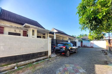 Önünde park edilmiş ev ve arabaların görüntüsü