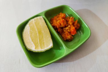 Portakallar ve biber sosu masada küçük bir tabakta.