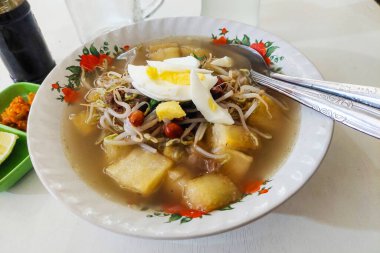 Indonesian Food Upi soup with chili sauce, soy sauce and orange on the table clipart